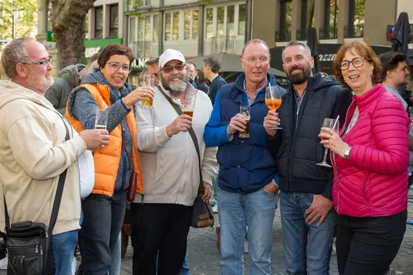 Eine Gruppe älterer und jüngerer Gäste stößt mit Getränken an
