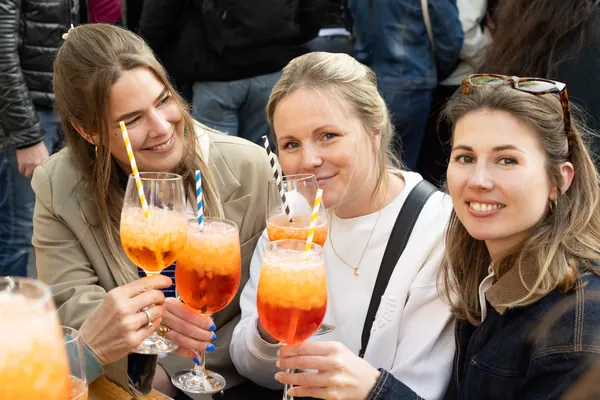 Drei Frauen stoßen mit Aperol Spritz an