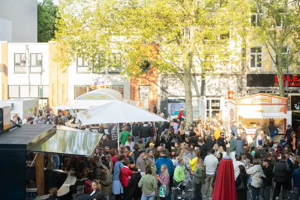 Dichtes Gedränge auf dem Chlodwigplatz zwischen Imbissständen und Bäumen