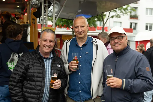 Drei Männer mit Bier und Wein in der Hand