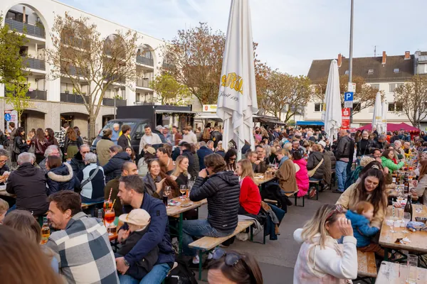 Volle Tische und viele Gäste auf dem Hermeskeiler Platz unter Bäumen