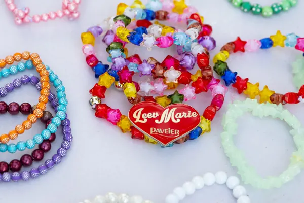 Bunte Perlenarmbänder mit rotem Herz auf einem Tisch