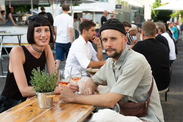 Ein Paar sitzt an einem Holztisch mit Lavendel und Spritz